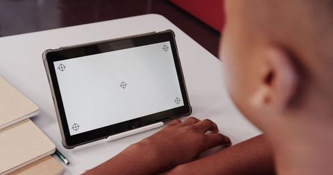 Student engaging with tablet screen in classroom setting