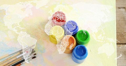 Colorful paint jars and brushes featuring world map overlay for global creativity