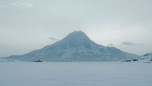 Minimalist Alpine Landscape Solitary Snow-Covered Mountain Rising Above Frozen Plain
