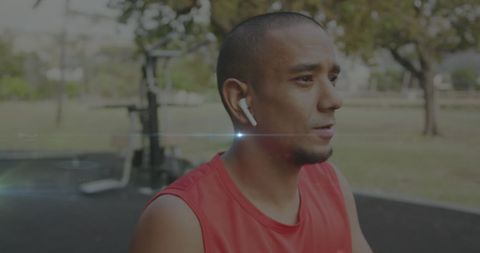 Focused Athlete Exercising with Earphones in Park