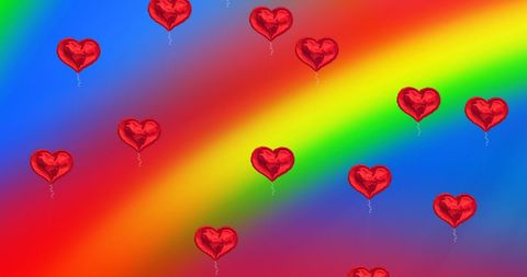 Heart balloons on vivid rainbow background celebrating pride
