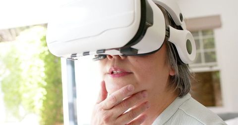 Senior Asian Woman Experiencing Virtual Reality Technology Indoors