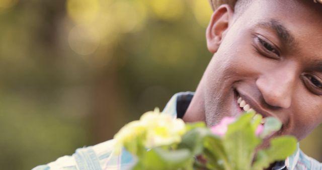 Smiling African American Man Enjoying Nature with Flowers - Download Free Stock Images Pikwizard.com