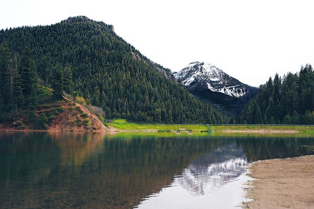 Tranquil mountain lake with clear reflection of snow-capped peak. Ideal for promoting travel, outdoor activities, adventure, nature retreats, and scenic destinations.