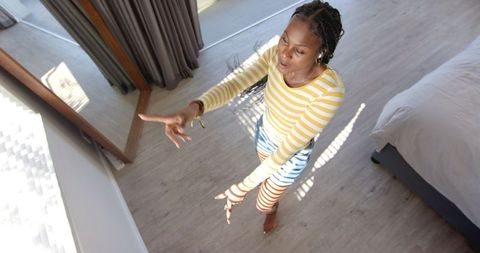 Young Woman Reaching in Modern Home Interior