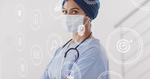 Clinician in turban and mask presenting telemedicine hud with medical data and analytics
