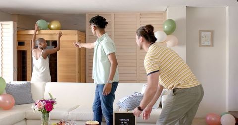 Friends Decorating Modern Living Room for Festive Celebration