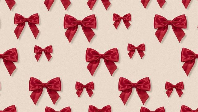 Seamless red satin bow pattern on cream background for gift wrap holiday and party design