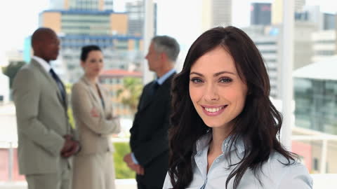 Confident Businesswoman Smiling with Team in Modern Office