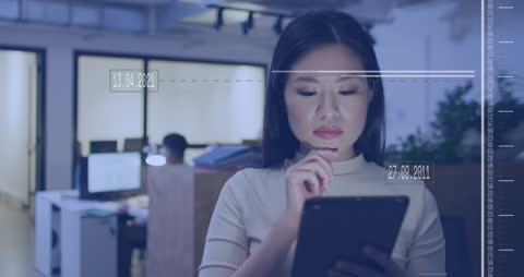 Businesswoman Analyzing Data on Digital Tablet with Graphics