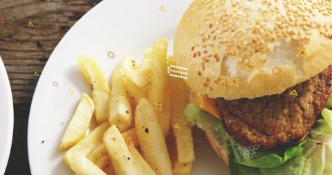 Closeup Showing Sesame Seed Burger with Lettuce and Thick-Cut Peppered Fries on Rustic Wood