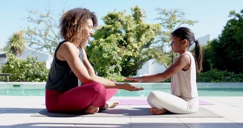Happy Mother and Daughter Practicing Yoga Together Outdoors