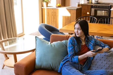 Relaxed Woman Sitting with Smartphone in Casual Living Room Setting