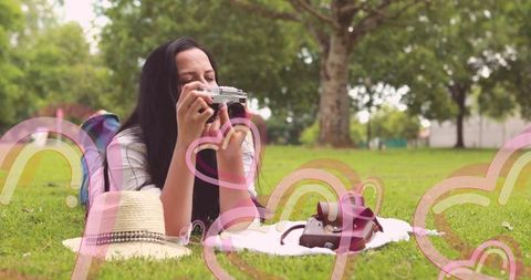 Young Woman Enjoying Photography in Park with Vintage Camera