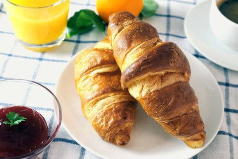 Delicious croissants and breakfast setting with juice