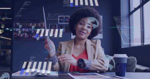 Businesswoman reviewing analytics reports with digital data overlays in modern office