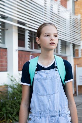 Teen Student Standing with Backpack Outside School Building