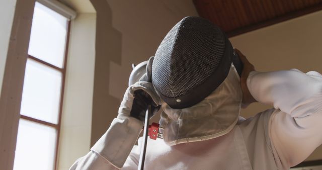 Fencer Preparing for Match by Putting on Helmet - Download Free Stock Images Pikwizard.com