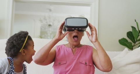 Grandmother and Granddaughter Using VR Headset in Living Room