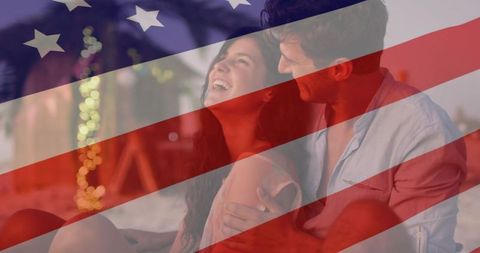 Romantic couple laughing on beach at twilight with american flag overlay
