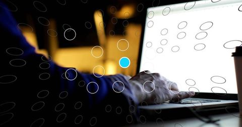 Freelancer's hand typing on laptop keyboard in modern workspace