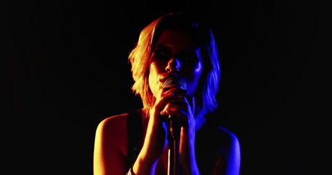 Young Female Singer Performing with Dramatic Stage Lighting - Download Free Stock Images Pikwizard.com