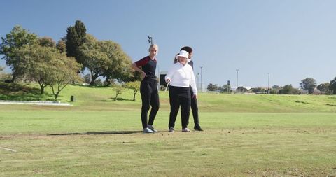 Female Golfers Practicing Putting on Sunny Day