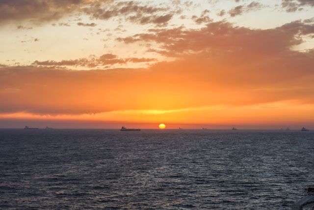 Stunning Sunset Over Ocean with Distant Ships - Download Free Stock Photos Pikwizard.com