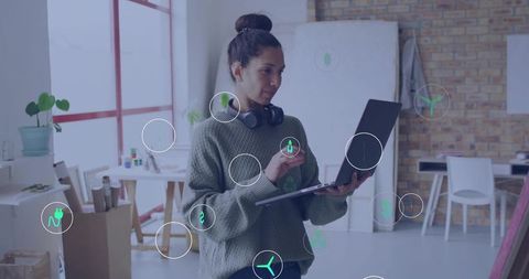 Creative designer using laptop with stylus in bright loft studio