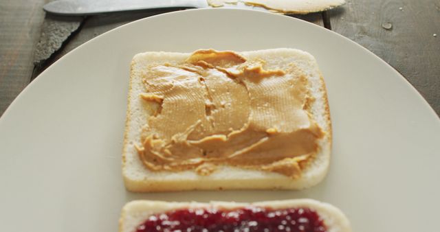 Close up view of peanut butter and jelly sandwich in a plate on wooden surface. food and nutrition concept
