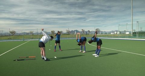 Female Hockey Players Stretching Warm-Up on Artificial Turf Field