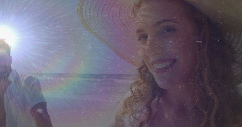 Smiling Woman in Straw Hat Enjoying Serene Beach with Lens Flare