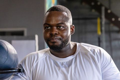 African american man lifting barbell for intense strength training and gym workout