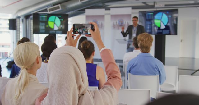 Diverse audience capturing business presentation on smartphone in modern conference room - Download Free Stock Images Pikwizard.com