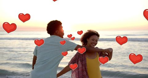 Romantic Couple Dancing on Beach at Sunset with Hearts
