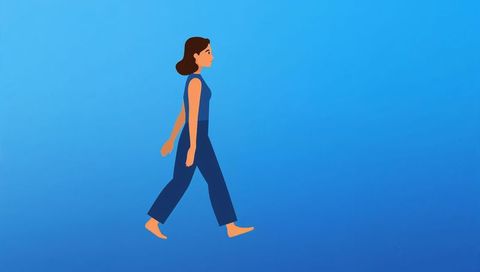 Woman walking in sleeveless top and wide pants on minimalist blue gradient background