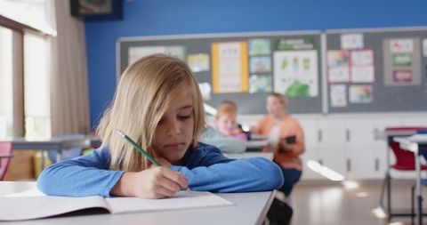 Young Student Writing in Classroom Setting