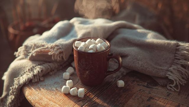 Cozy Warmth: Steaming Hot Drink with Marshmallows on Rustic Table