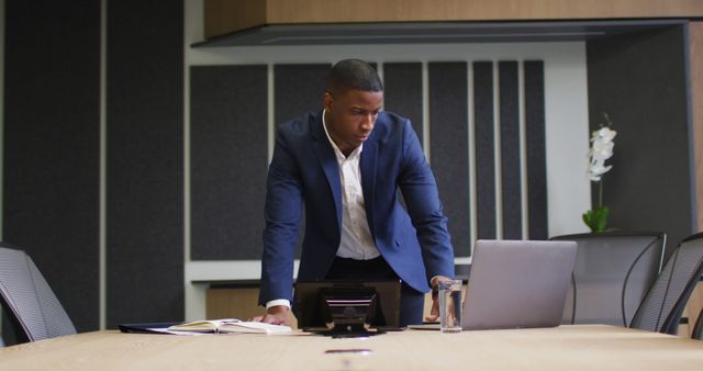 African american businessman using laptop in conference room in modern office. business and business people in office concept.