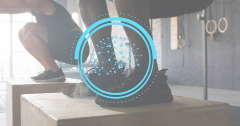 Performing plyometric box step-ups in industrial gym with blue tech overlay and teamwork