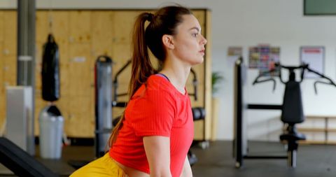 Young Woman Lifting Barbell in Modern Gym Training Session