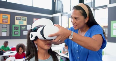 Teacher Assisting Student in Virtual Reality Experience at School