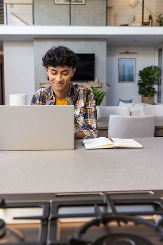 Young Man Engaging in Productive Work from Modern Kitchen