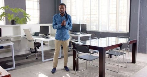 Confident Businessman Clapping in Modern Office Celebrating Success