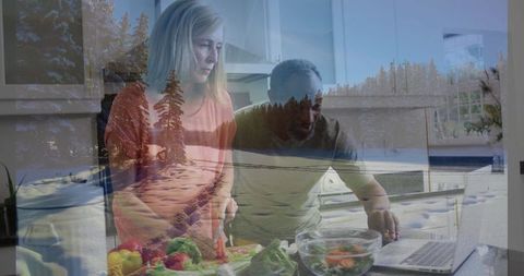 Couple in Kitchen Preparing Salad with Laptop Guidance
