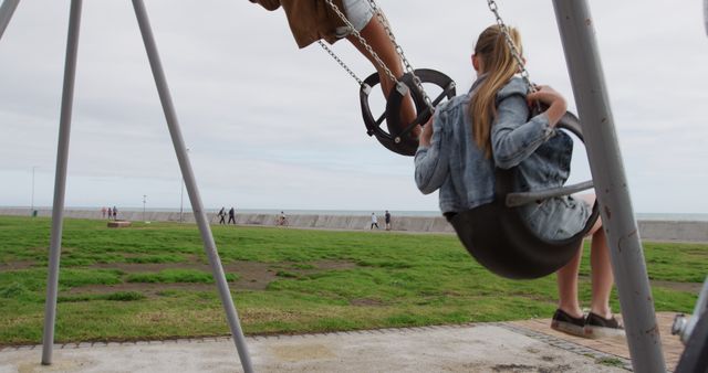 Children Swinging on Playground with Ocean View - Download Free Stock Images Pikwizard.com