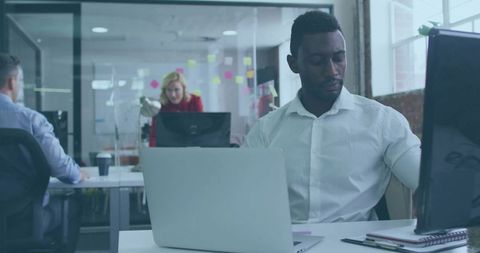 Business Professional Focusing on Laptop in Modern Open Office