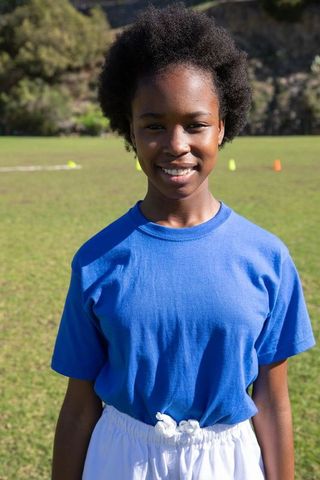 African American Female Teen Practicing Sports Drills on School Field
