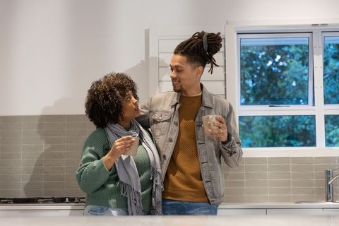 Couple sharing morning coffee at cozy modern kitchen countertop, warm connection