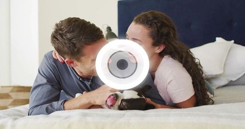 Couple cuddling with boston terrier on bed sharing intimate cozy morning moment